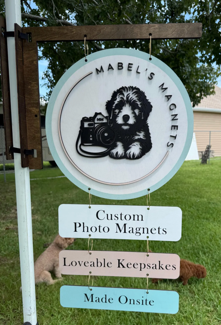Mabel's Magnets sign with a dog and camera illustration, featuring text about custom photo magnets.