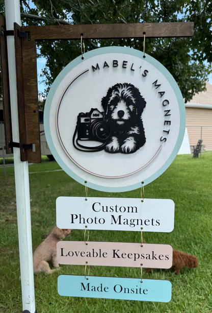 Mabel's Magnets sign with a dog and camera illustration, featuring text about custom photo magnets.